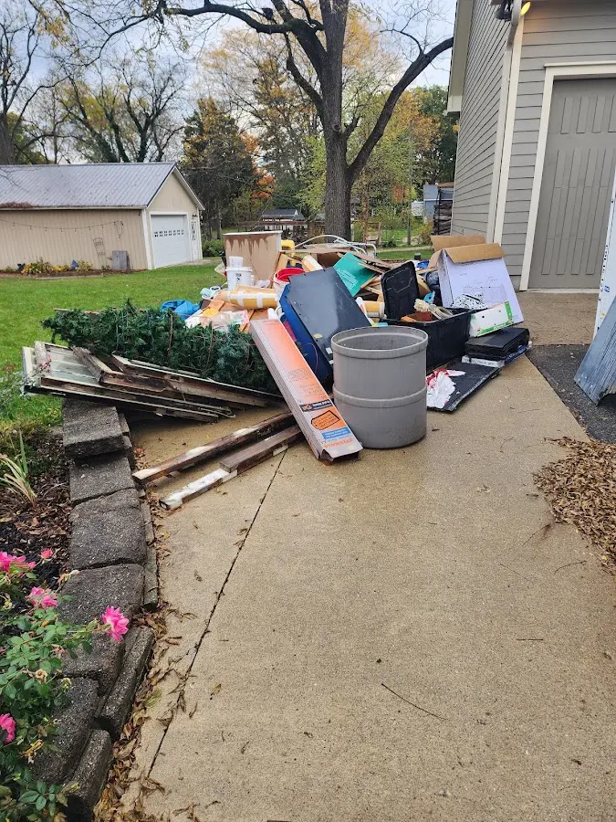 Dumpster being loaded with debris for Estate Cleanout Dumpster Rental in Indianola
